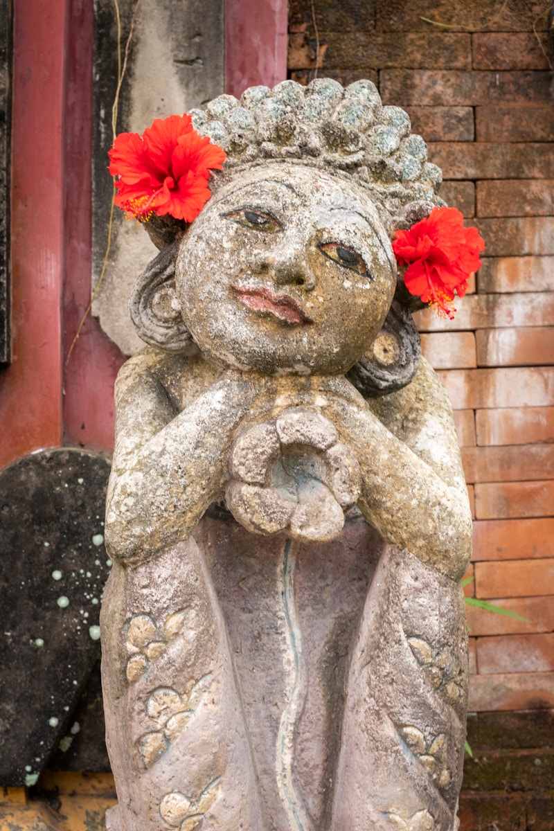 a statue of a person with a flower on the head